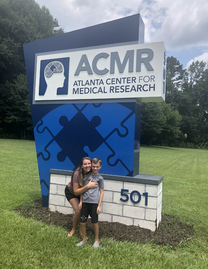 Mother and child standing in front of the Atlanta Center for Medical Research